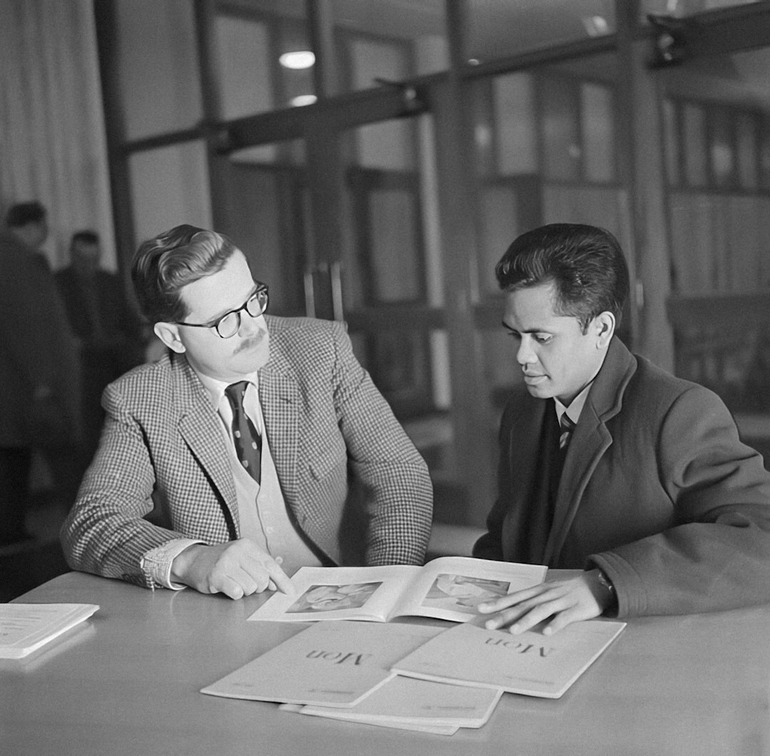 Divers team van Nederlandse erfgoedconservatoren dat samen documenten bestudeert in een archief